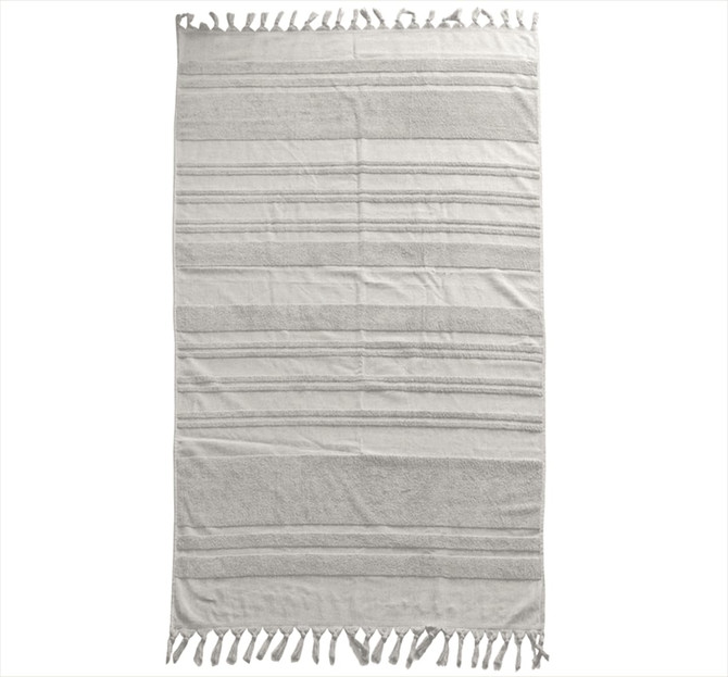 A flat, terry towel in light grey with stripes and tassels along the edges. It has a simple design and a soft texture.