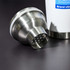 A drink bottle with a stainless steel shaker lid, showcasing a perforated design on a dark surface.