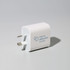 A white fast charge adapter with two prongs and a logo on the side, designed for phone and technology use.
