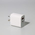 A white 20W fast charge adapter with two ports and a logo, suitable for travel.