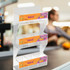 A clear acrylic display stand with three levels, featuring colourful graphics and a logo.