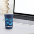 A blue plastic stadium cup featuring a geometric pattern and a logo, placed next to a laptop.