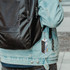 A custom square cube with keyrings attached to a backpack, featuring a colourful design and a logo.