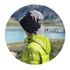 A grey foldable bucket hat is worn by a person in a green jacket, with a scenic landscape in the background.