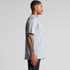 A grey Block Tee featuring a relaxed fit, displayed on a model from the side, showcasing its design and silhouette.