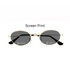 Oval retro sunglasses with a gold frame and dark lenses, featuring black temple arms and a logo.