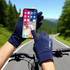 A pair of navy sun protective gloves with two open fingers, worn while using a smartphone outdoors.