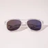 Clear frame sunglasses with dark lenses, featuring a sleek design and subtle branding.