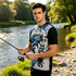 A men's fishing T-shirt featuring a blue and black design with fish graphics, set near a riverbank.
