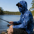 A blue camo fishing hoodie made from polyester and spandex, featuring a pocket and a logo, worn by a person by the river.
