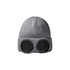 A grey beanie featuring large black goggles on the front, with a textured knit design. It includes a logo.
