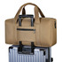 A durable duffle bag in tan sits atop a wheeled suitcase, featuring dual handles and a zippered pocket.