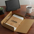 A cardboard gift box containing a bamboo notebook, pen, tablet, coffee cup, glasses, and a small plant.