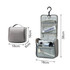 A grey hanging travel toiletry bag with compartments and a hook for easy access. Contains various toiletry items.
