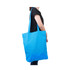 A bright blue long handle cotton bag is held by a person, featuring an unbranded design.