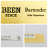 A metal name badge in gold with a brushed finish, featuring a silver backing. Includes a logo.