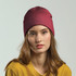 A maroon beanie worn by a model with long hair, paired with a yellow top, featuring a branding logo.