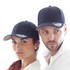 Two individuals are wearing navy blue caps featuring a logo. The caps have a classic design with a curved brim.