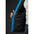 A close-up of a men's softshell jacket featuring blue exterior and a black lining, with a hand holding the open zipper.