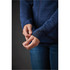 A navy blue women's jacket features textured fabric and fitted cuffs, with hands adjusting the sleeve.