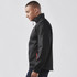 A men's black jacket with red accents, featuring a high collar and zipper pockets. It has a logo on the front.