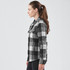A women's shacket in black and white checkered pattern, featuring a collar and pockets, displayed from the side.