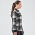A women's black and white plaid jacket featuring a button-up front, chest pockets, and a quilted design.