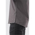 A grey button-up shirt with a subtle pattern, featuring side slits and a modern cut. It has a logo on the label.