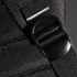 A detailed close-up of a black backpack strap featuring a plastic buckle, showcasing its durable materials and design.