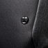 A close-up of a black fabric texture featuring a round black logo on a backpack.