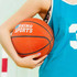 A basketball held by a person wearing a teal sports jersey, featuring a logo and a number. The ball is orange.