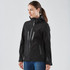 A black women's softshell jacket featuring zippered pockets and a hood, with subtle reflective accents.