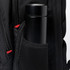 A black drink bottle is nestled in the mesh side pocket of a black backpack featuring red accents and a logo.