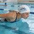 A seamless silicone swimming cap in white is worn by a swimmer performing a stroke in a pool.