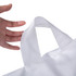 A hand holding a white bag with a handle, showcasing the bag's design and stitching details.