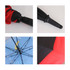 An expandable golf umbrella in red and black, showcasing its handle, ribs, and inner structure. Features a logo.