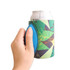 A drink bottle holder in vibrant green and blue with a textured grip, featuring a colourful geometric design.