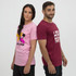 A pink unisex T-shirt with a graphic design and a maroon unisex T-shirt with text. Both models stand back to back.