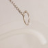 A clear, flexible sign holder with a silver metal hook attached to a chain.