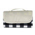 A folded picnic blanket featuring a black and white checkered pattern with a beige handle. It has a sleek design and logo.