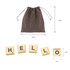 A set of cream-coloured letter tiles spelling "HELLO" with a brown drawstring pouch for storage.