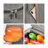 A large grey cooler backpack with an orange interior, containing fruits and a pocket for a phone and tablet.