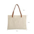 A canvas bag with leather straps, featuring a cream colour, measuring 64cm x 45cm x 35cm. Includes a brand logo.