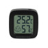 A square black digital thermometer displaying temperature and humidity readings. Features a smiling face icon.