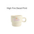 A stackable ceramic mug in cream with a floral design and branding visible.
