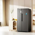 A black fridge stands beside a light wooden cabinet in a bright, modern space. The fridge features a logo on its door.