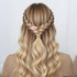 A hair style featuring intricate braids with a pink teardrop iridescent alligator hair clip holding a half-up section.