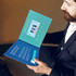 A 4.3-inch LCD video brochure in blue, featuring a play button and display screen, held open by a person.