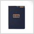 A navy notebook with a textured cover and a brand logo in the centre. Features an exterior pocket.