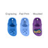 Three pairs of clog shoe-shaped charms in blue, light blue, and purple, featuring one with a design. Each has a branding logo.